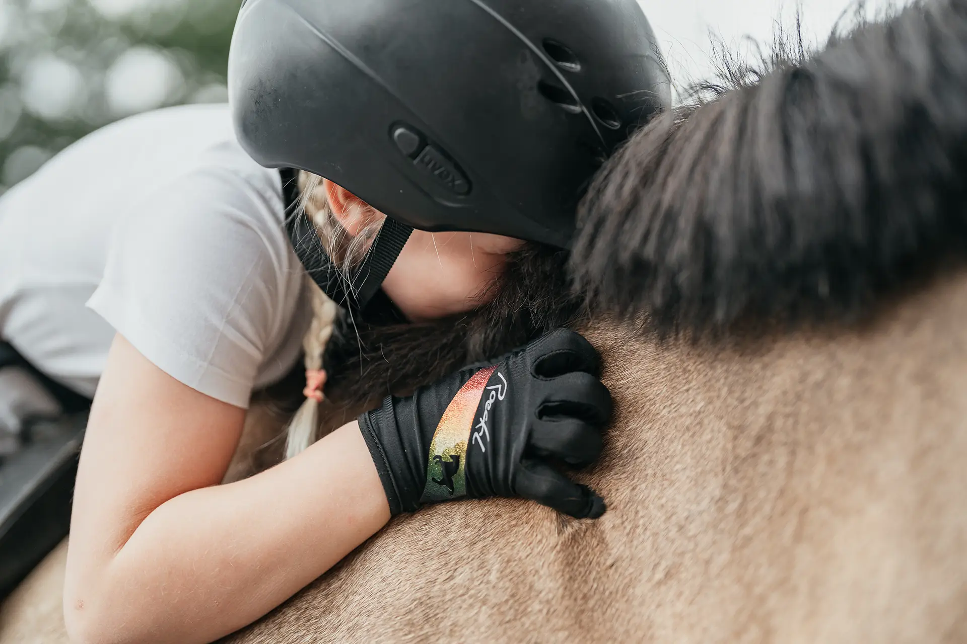 Ponyreiten Ein Mädchen krault und kuschelt mit einem Pony